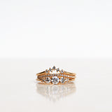 Ring stack with three Mumbaistockholm Fine Jewelry Rings:  Elise Ring in 18K yellow gold with five white, conflict-free diamonds, Jade Petite Wave Half Ring with a curved band half covered with 0.005 CT diamonds TWVS, and Five Diamond Triangle Ring with five 0.02 CT diamonds TWVS.